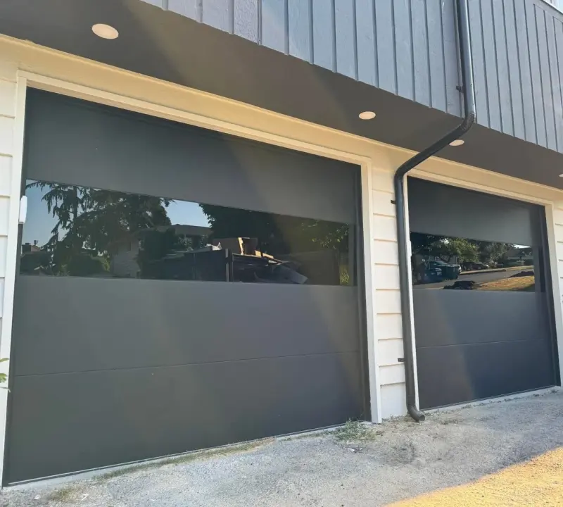 Two dark flush garage doors with a band of glass.