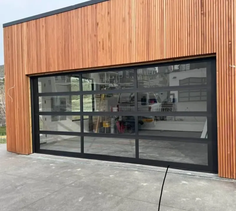 A full-window aluminum and glass garage door in a timber-clad garage.