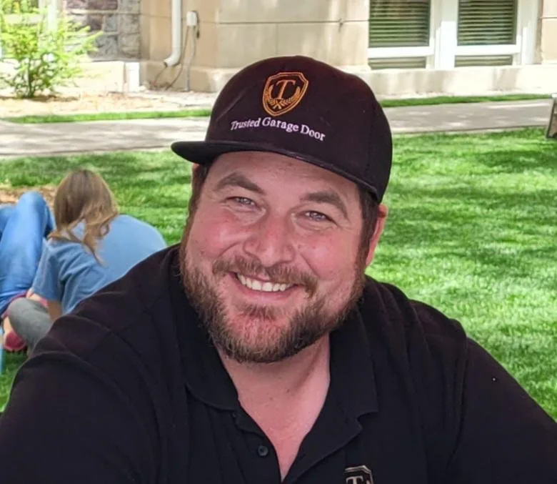 Peter in a Trusted Garage Door cap, smiling.